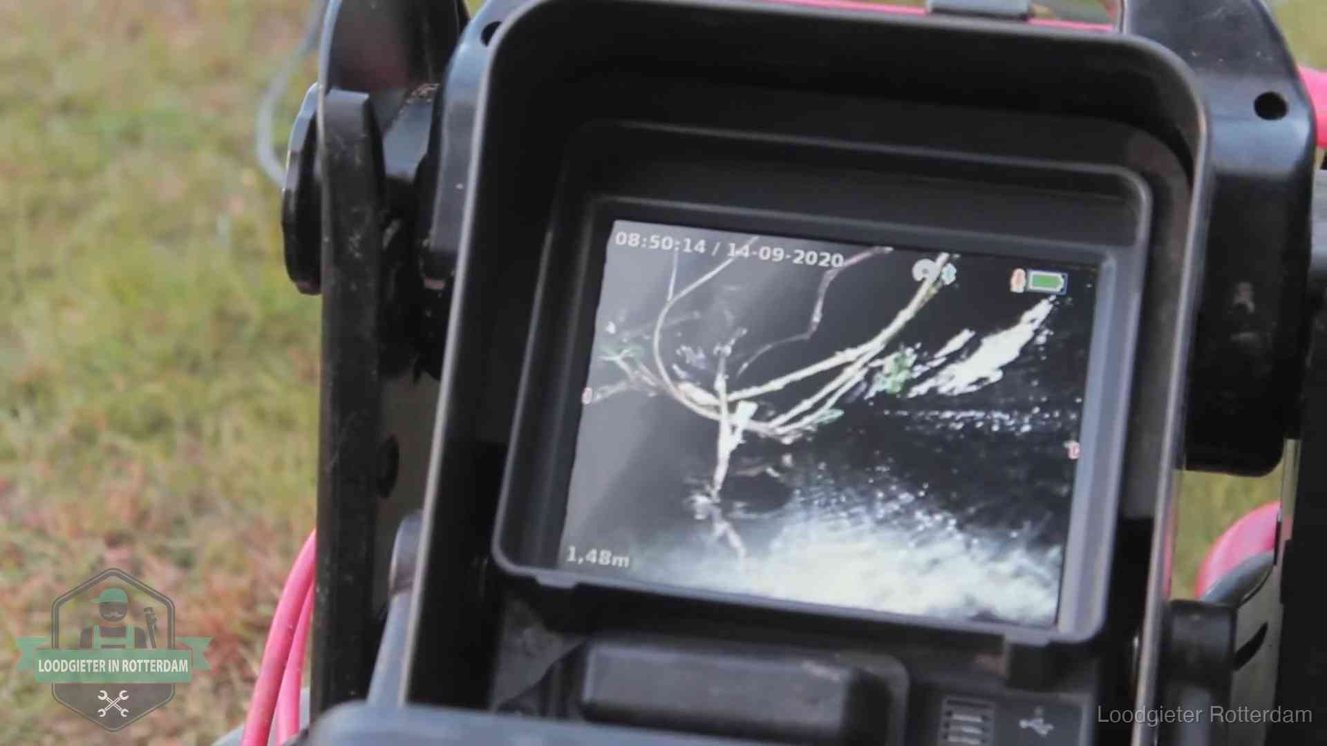 Monitor van een rioolcamera toont wortelingroei in de rioolbuis bij een woning in Rotterdam