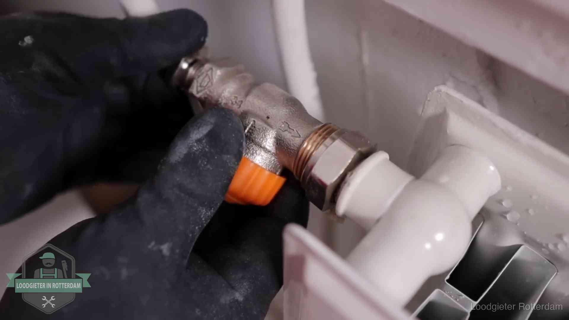 Thermostaatkraan wordt gemonteerd op een radiator in Rotterdam voor het stookseizoen