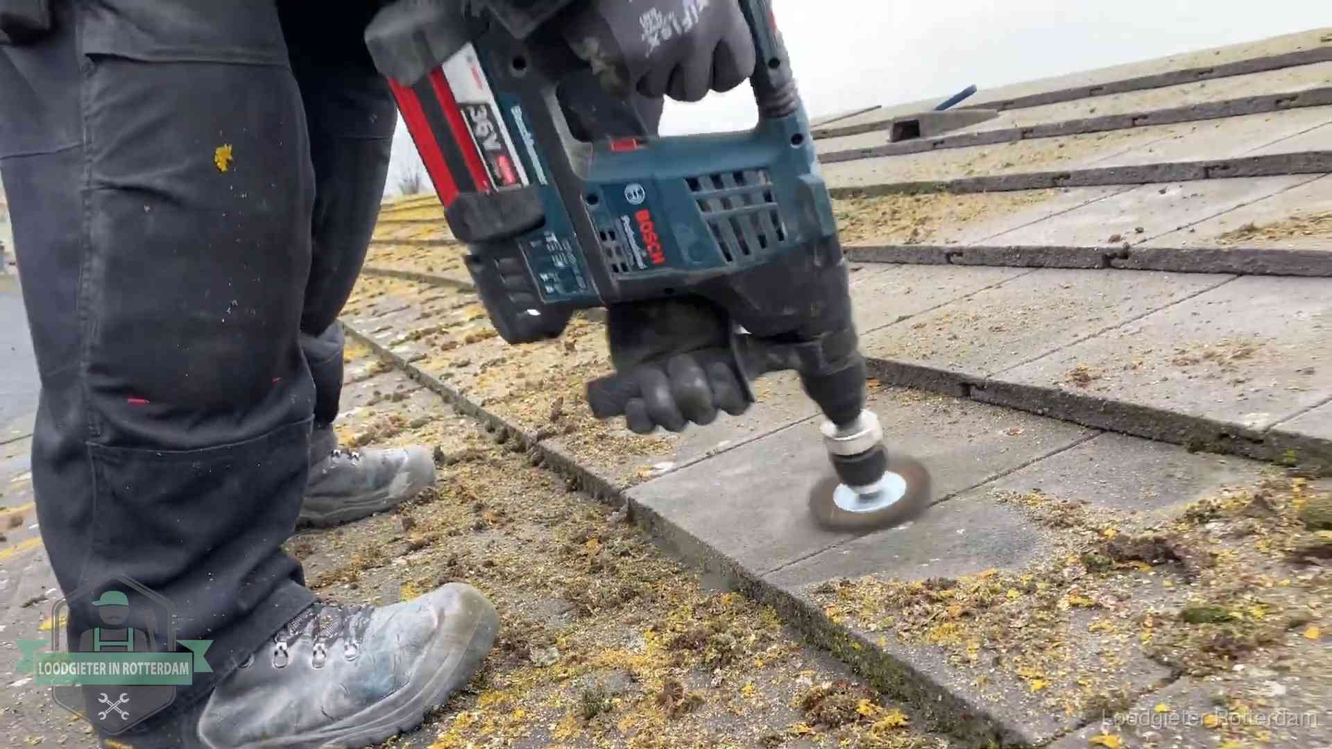 Dakonderhoud en preventie in Rotterdam Betonnen dakpannen worden machinaal gereinigd tijdens dakonderhoud in Rotterdam