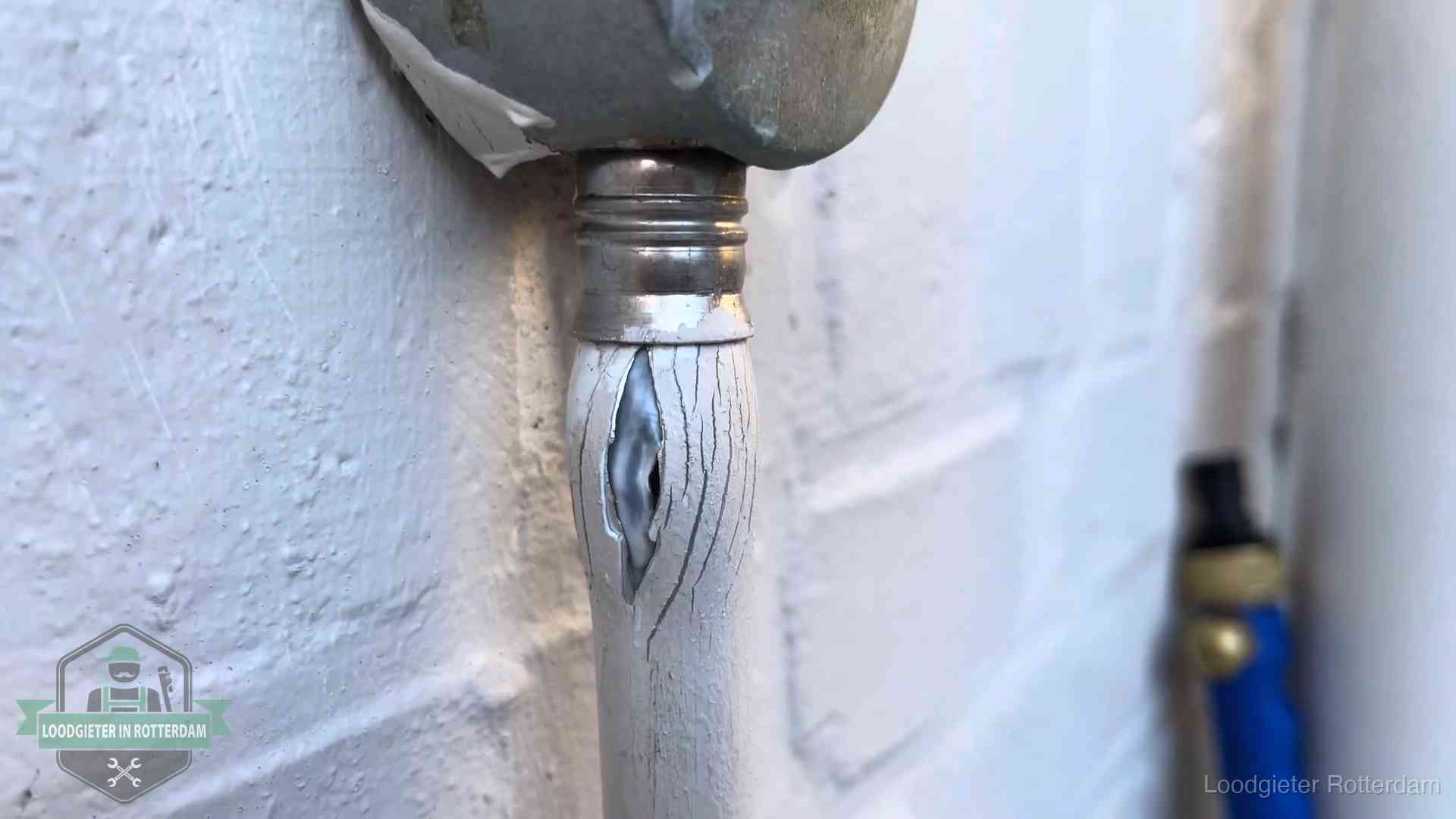 Oude waterleiding in Rotterdam waar de verf openscheurt, een stille aanwijzing voor een beginnend lek