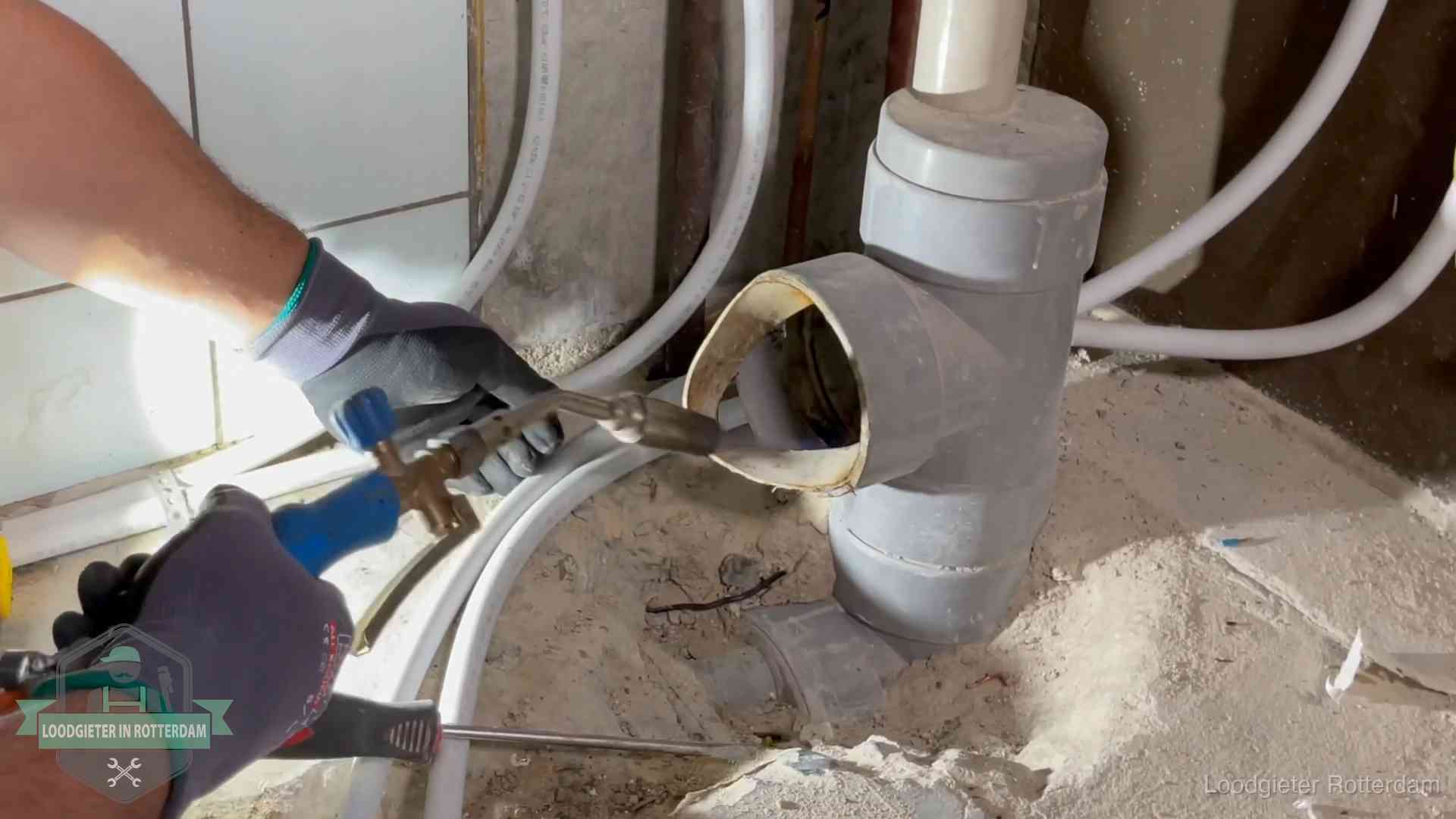 Vakmanschap van onze loodgieters in Rotterdam Loodgieter werkt met brander en messing kraanwerk aan leidingen in Rotterdam