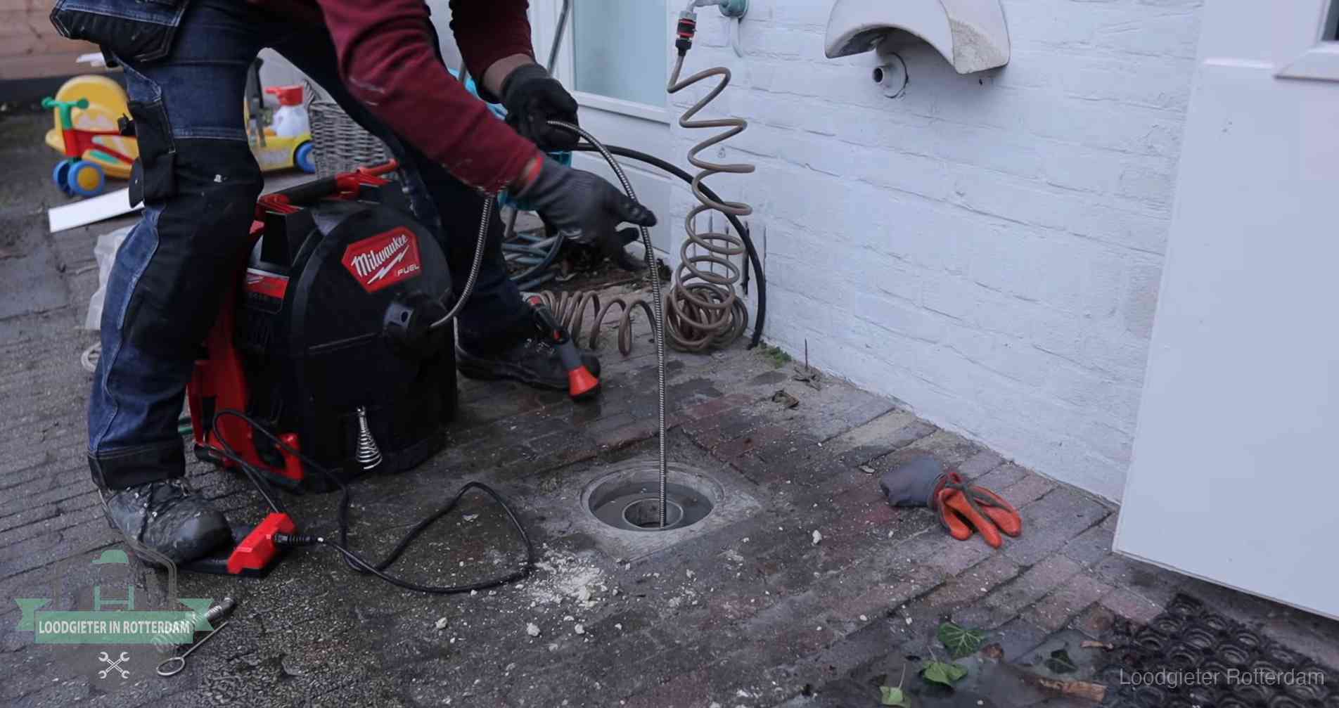 Ontstoppingsputje in de bestrating naast de gevel van een woning in Rotterdam