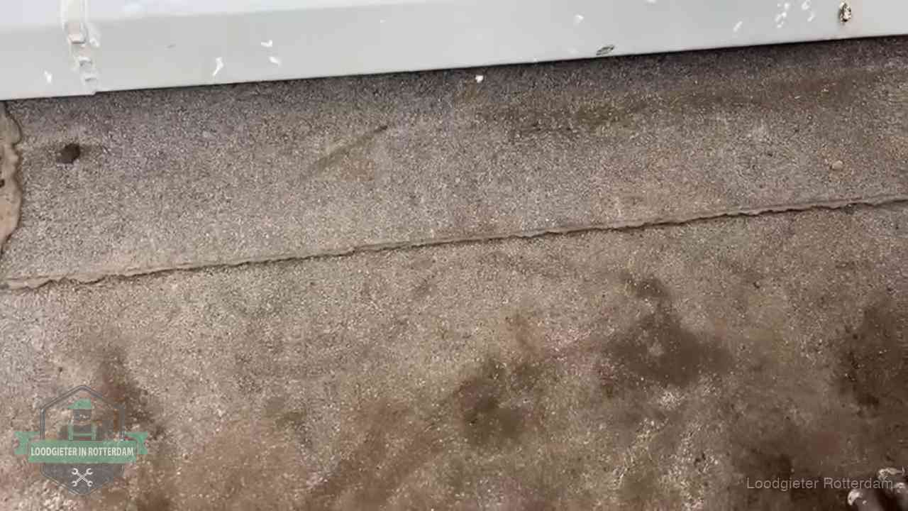 Stormschade en neerslag op daken in Rotterdam Vochtplekken bij de naad van een plat dak na aanhoudende regen in Rotterdam