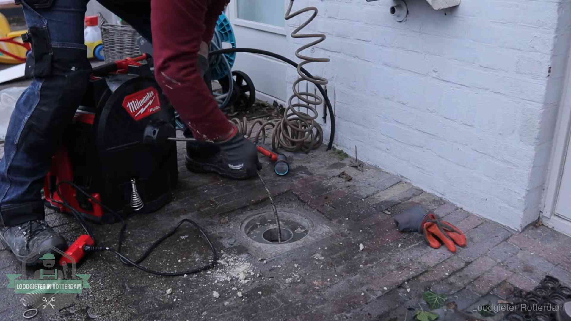 Spiraalmachine bij een ontstoppingsputje in de bestrating in Rotterdam
