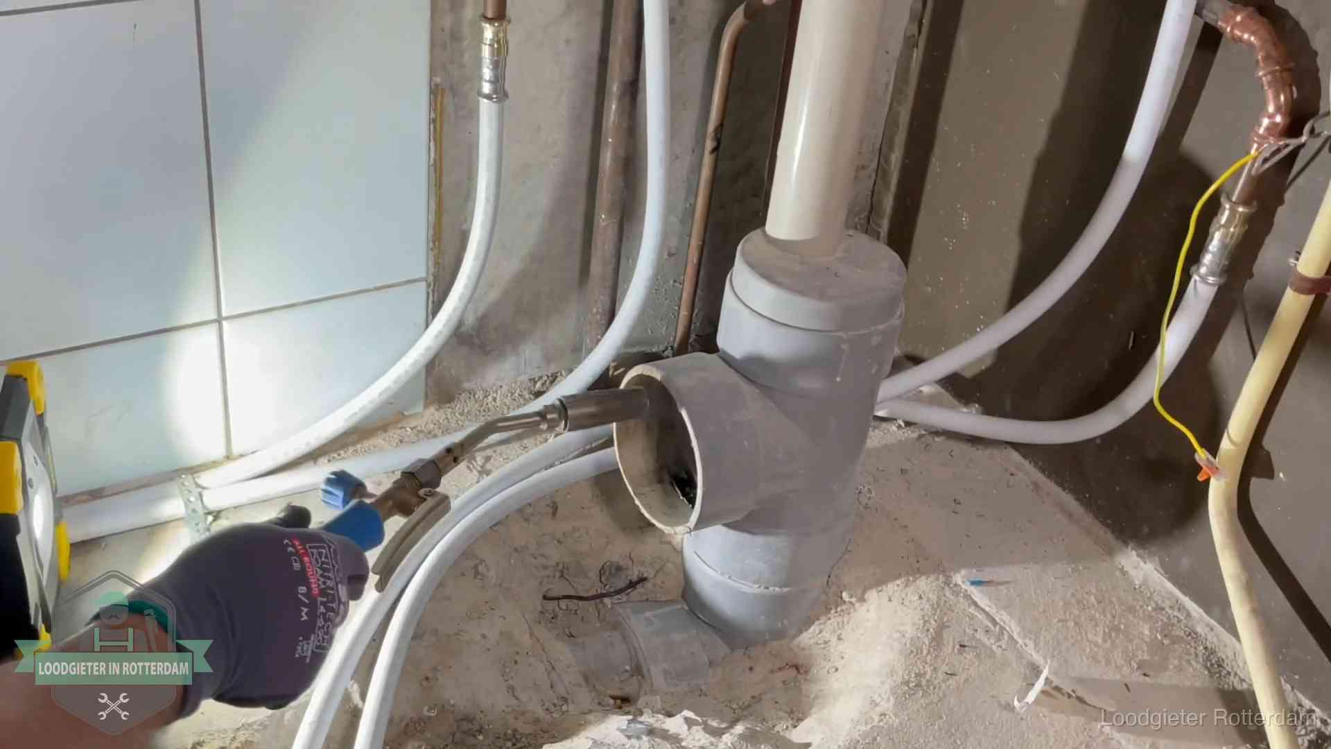 Loodgieter werkt aan leidingen bij de pvc-standleiding van een huurwoning in Rotterdam