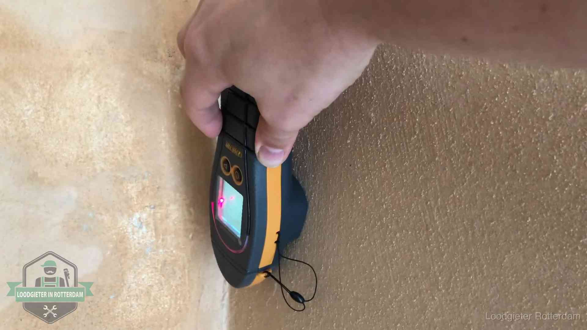 Daklekkage opsporen zonder hakwerk in Rotterdam Vochtmeter tegen een muur met vochtplekken tijdens het opsporen van een daklekkage in Rotterdam