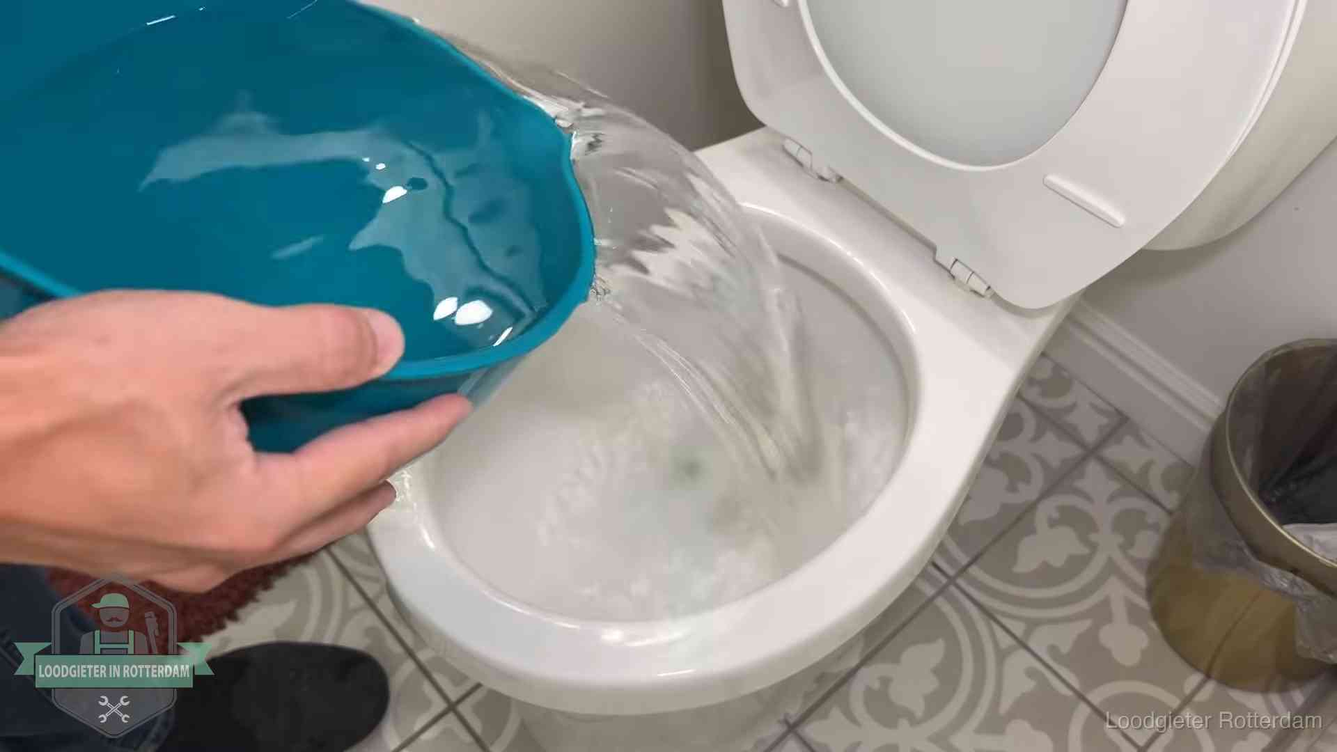 Warm water wordt voorzichtig in de wc-pot gegoten in Rotterdam