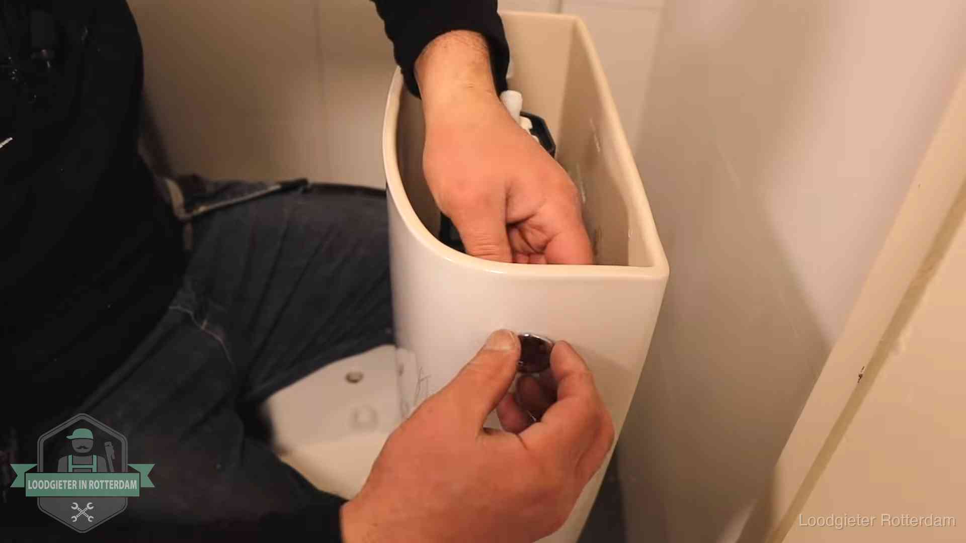Drukknop van een duoblok-stortbak wordt gemonteerd bij een toilet in Rotterdam