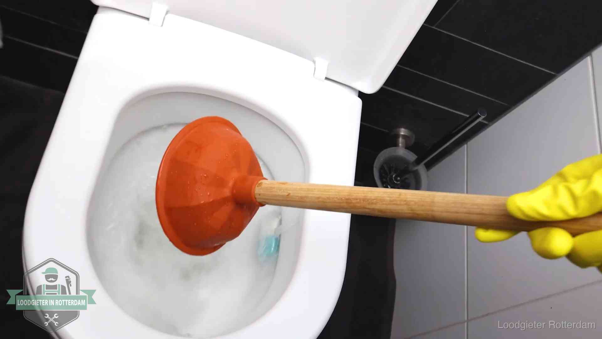 Plopper wordt in de wc-pot gedrukt bij het ontstoppen van een toilet in Rotterdam