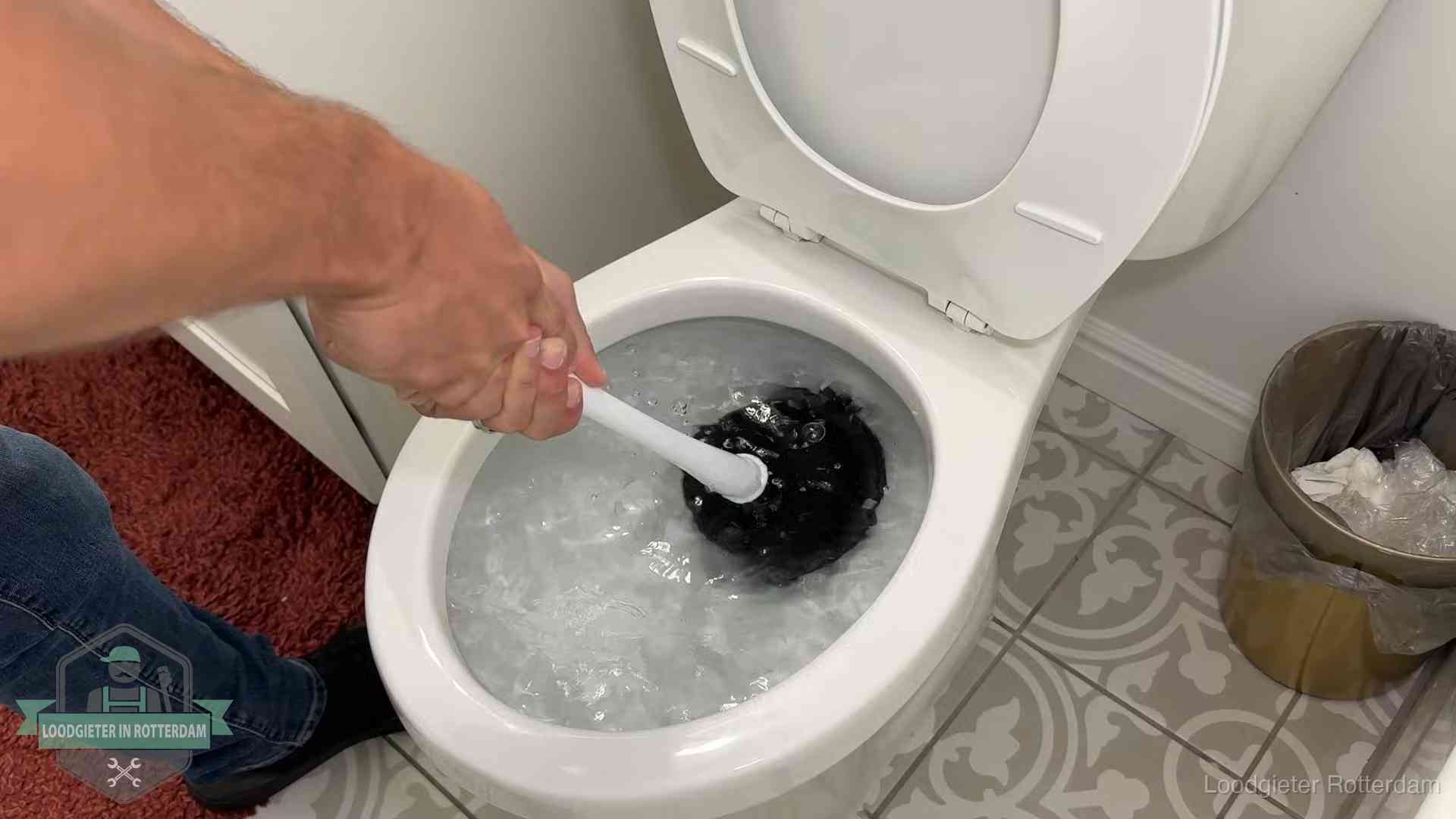 Zelf de wc ontstoppen met een plopper in Rotterdam, het water kolkt in de pot
